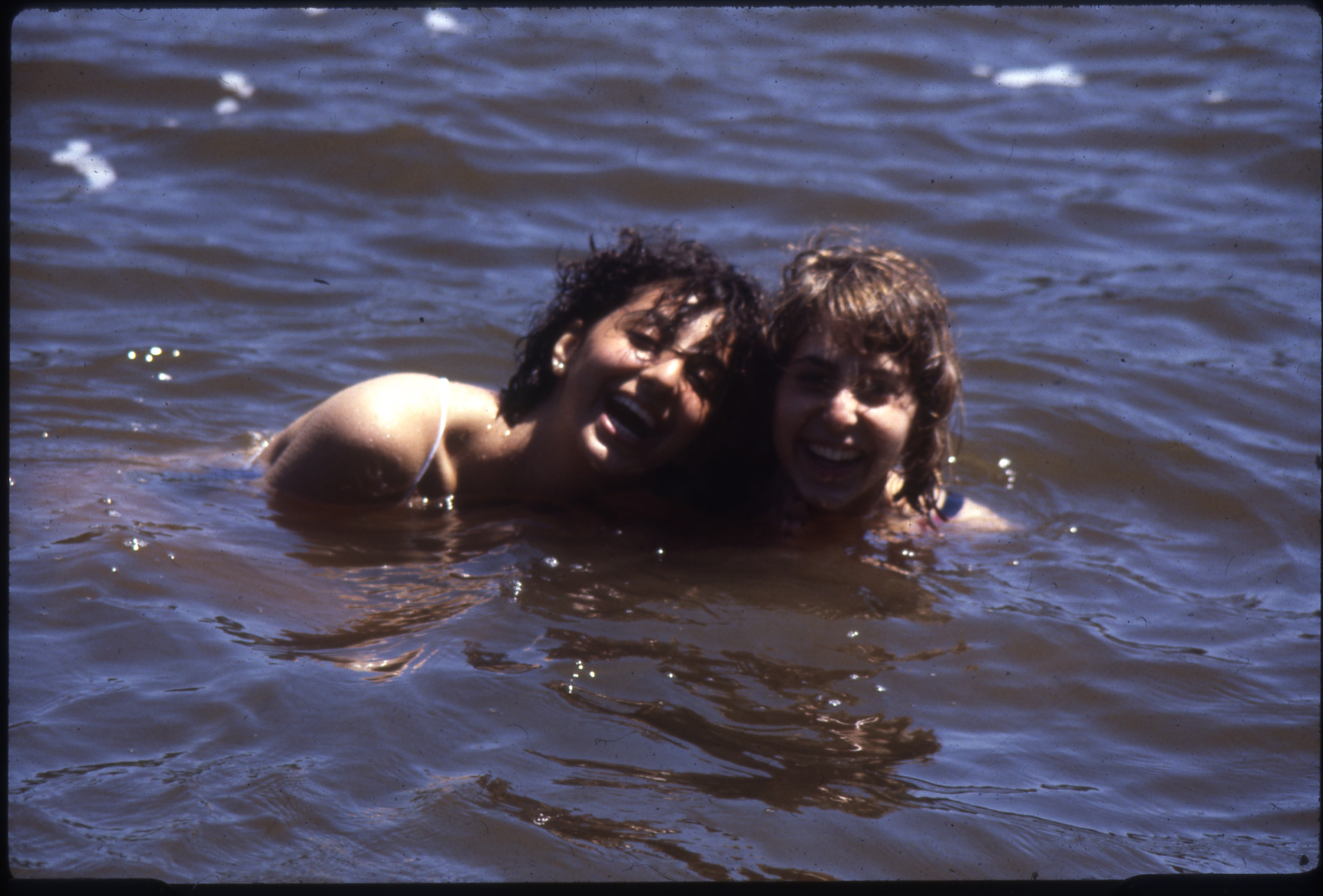 Two smiling campers enjoy a swim in a lake at Camp Shalom