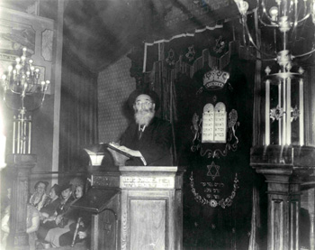 Photograph of Rabbi Langner in front of the eastern wall of the sanctuary