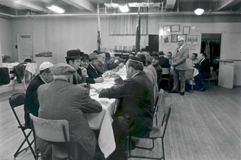 Male congregants attending a meeting over a meal in the Kiever’s social hall