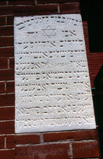 The stone memorial embedded in the exterior wall of the shul dedicated to certain members of the Kiever